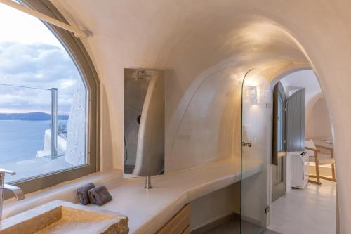 a bathroom with a sink and a window at Aperto Suites - Adults Only in Fira