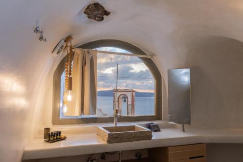 a bathroom with a sink and a window at Aperto Suites - Adults Only in Fira