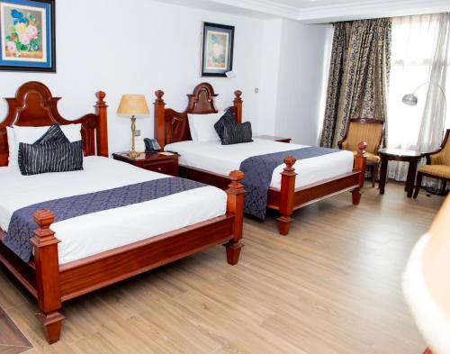 a hotel room with two beds and a window at Weston Hotel in Nairobi