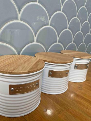 a row of white containers with wooden tops on a table at Wagait Beach Sanctuary in Wagait Beach