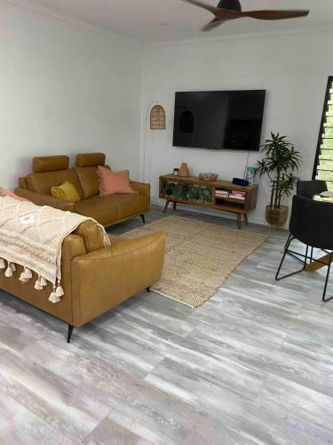 a living room with a couch and a flat screen tv at Wagait Beach Sanctuary in Wagait Beach