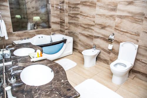 a bathroom with two sinks and a toilet at Weston Hotel in Nairobi
