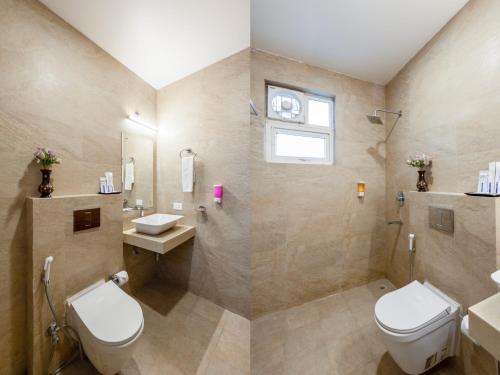 a bathroom with a toilet and a sink at Aadat Hotel Subhash Chowk Gurgaon in Gurgaon