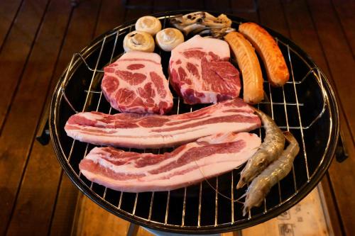 a plate of meat and vegetables on a grill at Hyeopjae MoonBeam in Jeju