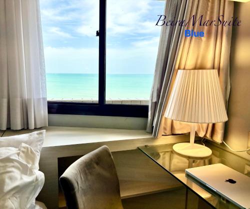 a bedroom with a window with a view of the ocean at Beira Mar Suite in Fortaleza