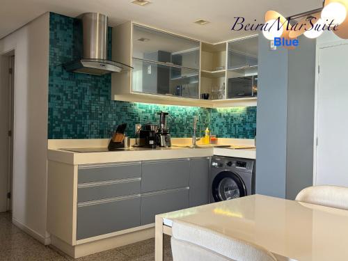 a kitchen with a sink and a washing machine at Beira Mar Suite in Fortaleza