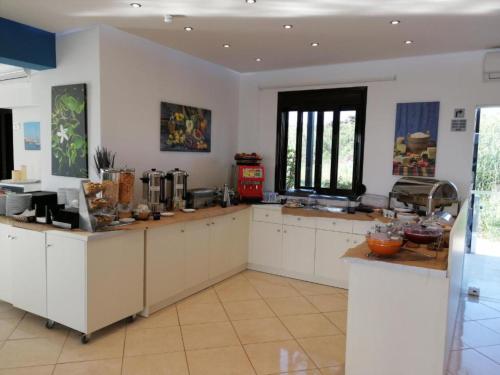 a large kitchen with white cabinets and counters at Carisa Suites and Apartments in Maleme