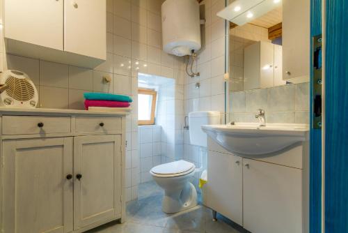 ein weißes Badezimmer mit Toilette und Waschbecken in der Unterkunft Casa Angeli in Banjol - Haus für 4-5 Personen in Rab