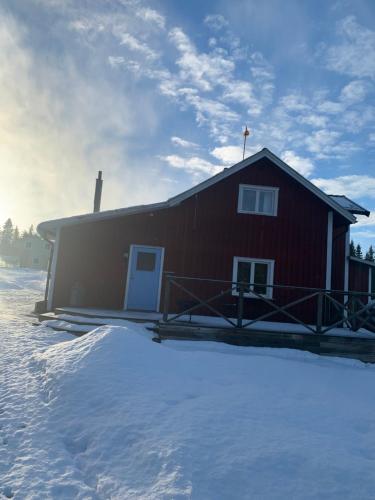 a red barn with snow in front of it at Warm beheiztes gemütliches Haus in der Natur in Sunne