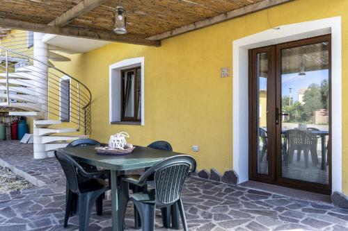 a table and chairs sitting outside of a house at Su Giuali in SantʼAnna Arresi