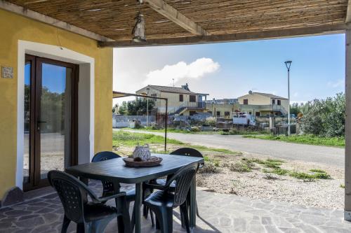 a table and chairs on a patio with a view of a street at Su Giuali in SantʼAnna Arresi