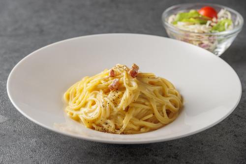 a white plate of pasta on a table at The Royal Park Canvas - Osaka Kitahama in Osaka