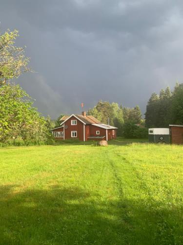 a red house in the middle of a green field at Warm beheiztes gemütliches Haus in der Natur in Sunne