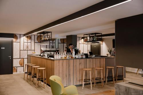 a man standing at a bar in a restaurant at Armon Greenblu Hotel & Wellness in Folgarida