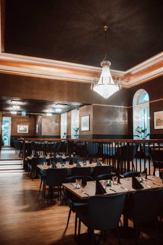 a dining room with tables and chairs and a chandelier at Meyer Hamina in Hamina