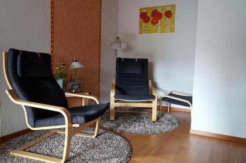 - deux chaises et une table dans le salon dans l'établissement Eifelferienhaus Thome, à Lissendorf