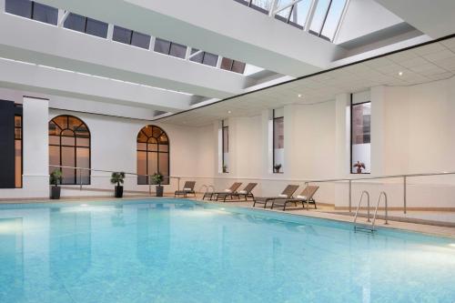 a large swimming pool in a building with chairs at Glasgow Marriott Hotel in Glasgow