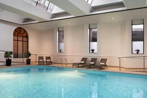 a large swimming pool in a building with chairs at Glasgow Marriott Hotel in Glasgow