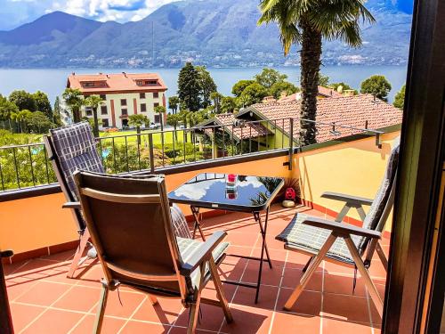 a patio with two chairs and a table on a balcony at Parco Ameno by Lago Reisen in Germignaga