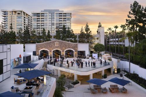 einen Blick über ein Gebäude mit Tischen und blauen Sonnenschirmen in der Unterkunft Irvine Marriott in Irvine