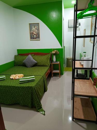 a green room with a bed and a ladder at MilVir Tourist INN in El Nido