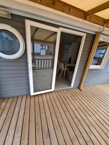 a screened porch with sliding glass doors on a house at Mobil-hom in Lège-Cap-Ferret