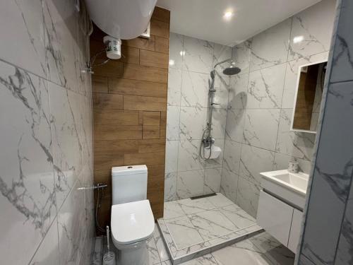 a bathroom with a toilet and a shower and a sink at Apartment Bela in Burgas City