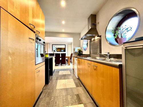 una cucina con mobili in legno e un lavello di Le Ny d'Ange a Stoumont
