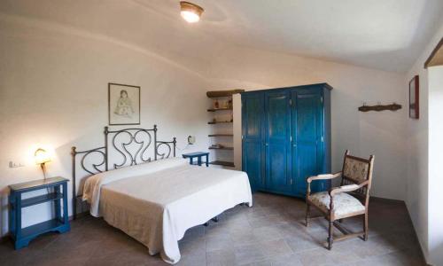 1 dormitorio con 1 cama, armario azul y silla en Borgo Podernovo, en Bolsena
