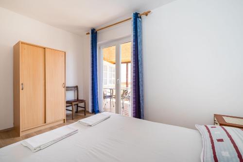 Un dormitorio con una cama y una puerta corrediza de vidrio. en Ivy Apartments in Center, en Novalja