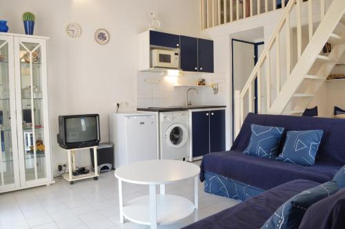 un salon avec un canapé bleu et une télévision dans l'établissement Maison 2 pièces mezzanine - Gruissan Ayguades AY110-402, à Narbonne-Plage