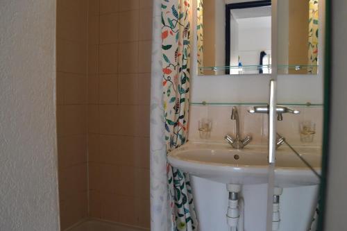 une salle de bain avec un lavabo et un miroir dans l'établissement Maison 2 pièces mezzanine - Gruissan Ayguades AY110-402, à Narbonne-Plage