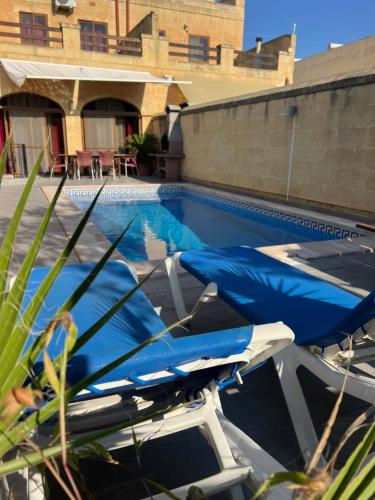 a swimming pool with a blue tarp next to a building at 4 Bedroom Holiday Home with Private Pool in Għarb