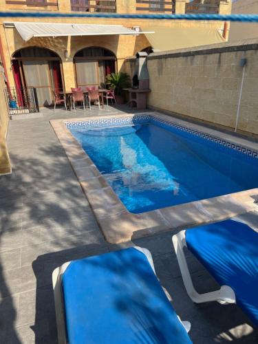 a swimming pool with blue water in a yard at 4 Bedroom Holiday Home with Private Pool in Għarb