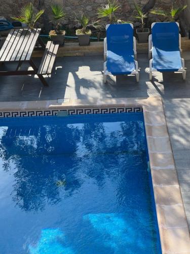 two chairs and a swimming pool with blue water at 4 Bedroom Holiday Home with Private Pool in Għarb