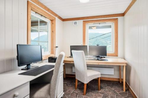 a home office with a desk with two monitors and chairs at Historic Farm With Panoramic Views In Gudbrandsdalen in Favang