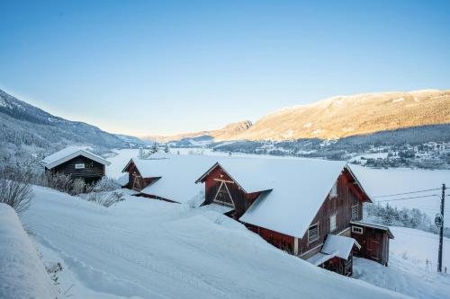 a group of cabins in the snow in a mountain at Historic Farm With Panoramic Views In Gudbrandsdalen in Favang