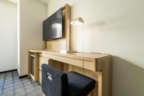 a room with a desk with a tv and a chair at The Royal Park Canvas - Osaka Kitahama in Osaka