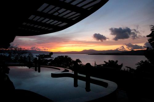 a view of a sunset from a resort swimming pool at NoaNoa Private Island in Taytay