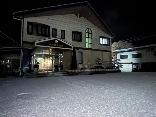 a building with a store in the snow at night at 令德湖畔山荘 in Yamanakako