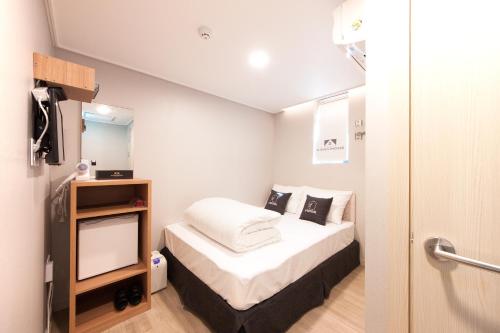 Un pat sau paturi într-o cameră la K-Grand Hotel Myeongdong