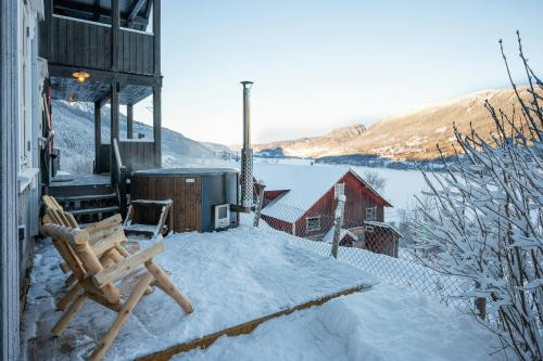 a snow covered patio with a bench and a building at Historic Farm With Panoramic Views In Gudbrandsdalen in Favang