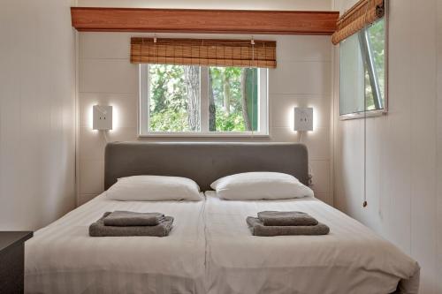 a bedroom with a large bed with two towels on it at Bosje 1 - Ouddorp NOT INTENDED FOR COMPANY OR WORK-RELATED STAYS in Ouddorp