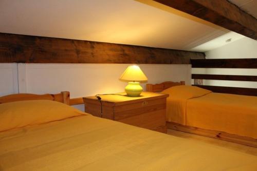 - une chambre avec 2 lits et une lampe sur une commode dans l'établissement Maison 2 pièces mezzanine - Gruissan GN490-046, à Gruissan