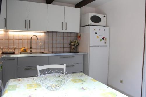 une cuisine avec une table et un réfrigérateur blanc dans l'établissement Maison 2 pièces mezzanine - Gruissan GN490-046, à Gruissan