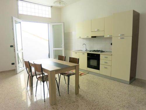 a kitchen with a wooden table and chairs at La Taverna 98 in Otranto