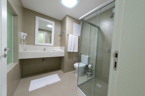 uma casa de banho com um WC, um lavatório e um chuveiro em Hotel Oma Zita em Forquilhinha