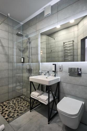 a bathroom with a sink and a toilet and a mirror at CHALET NEBO in Bukovel