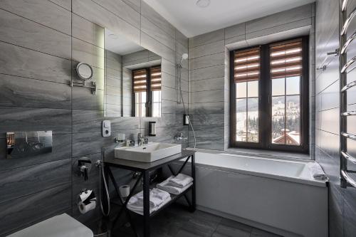 a bathroom with a sink and a bath tub at CHALET NEBO in Bukovel