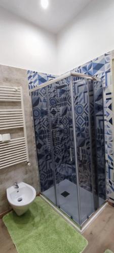 a bathroom with a glass shower with a sink at Mediterraneo Travel in Gela